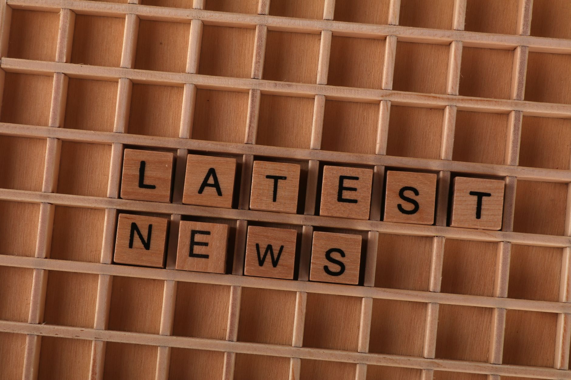 Wooden letter blocks spelling Latest News on a grid background, ideal for media themes. — Wie man sich bei Goldbet Casino reg